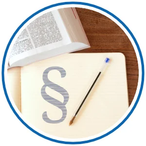aufgeschlagenes Buch, Stift und Paragraph-Symbol 