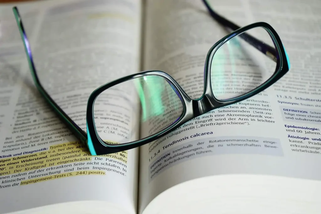 Brille auf offenem Buch